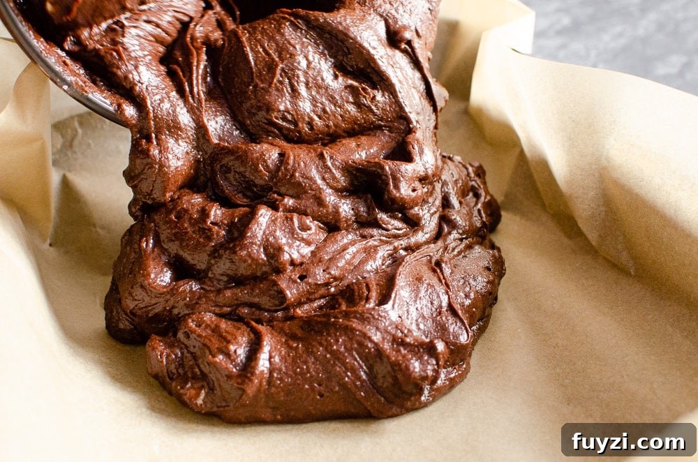 Fudgy Chunky Chocolate Chip Brownies Recipe 17 Pouring the brownie mixture into a parchment paper lined baking tray