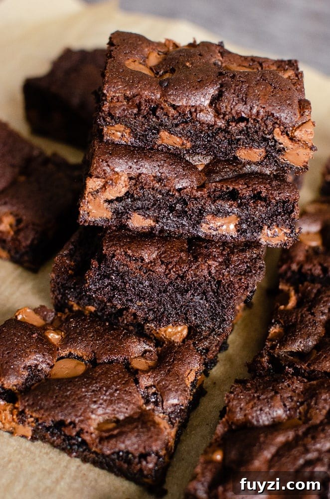 Fudgy Chunky Chocolate Chip Brownies Recipe 21 Chunky Chocolate Chip Brownies stacked up on brown parchment paper