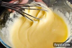 Fudgy Chunky Chocolate Chip Brownies Recipe 6 Whisking the butter mixture in a glass bowl with a black whisk