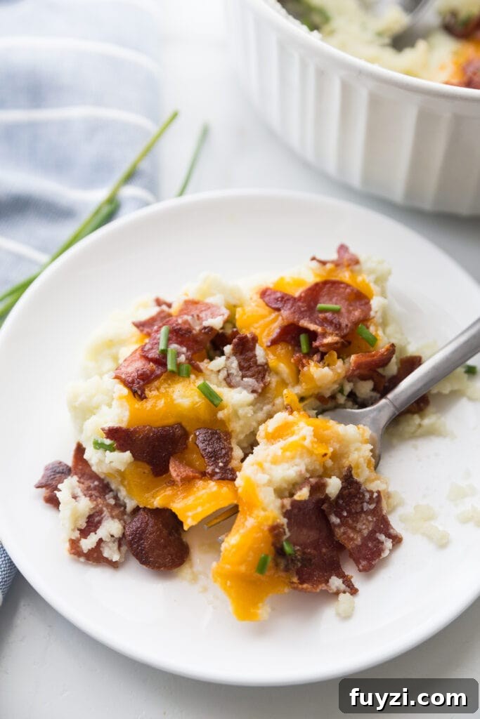 A small plate of Loaded Cauliflower Mashed Potatoes with bacon, cheddar, and chives.