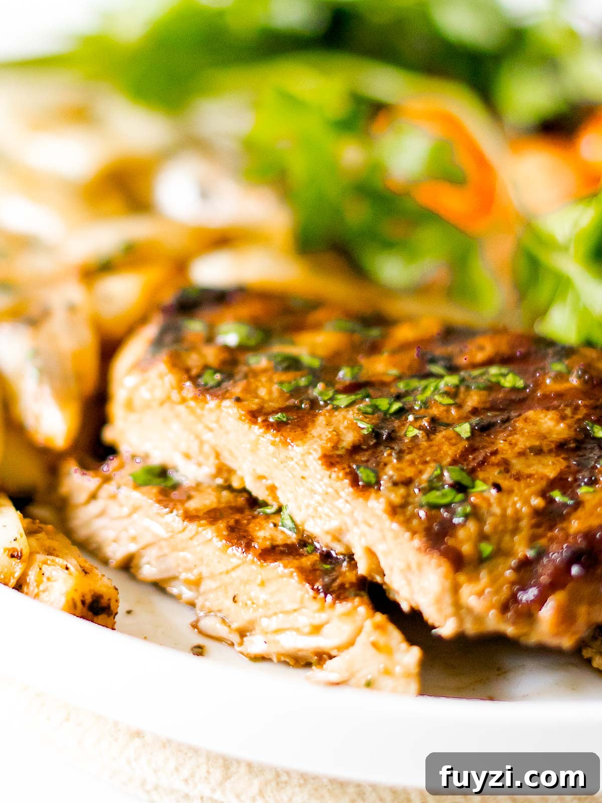 cross section of juicy easy grilled pork chops with grill marks on a white plate