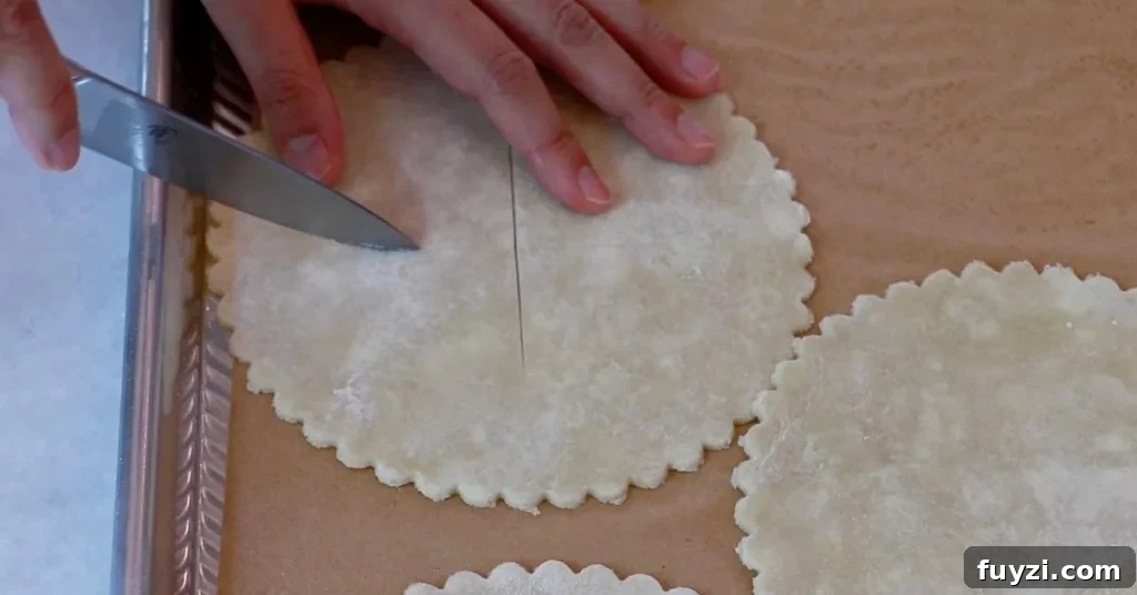 cutting the surface of pie dough for blueberry pies