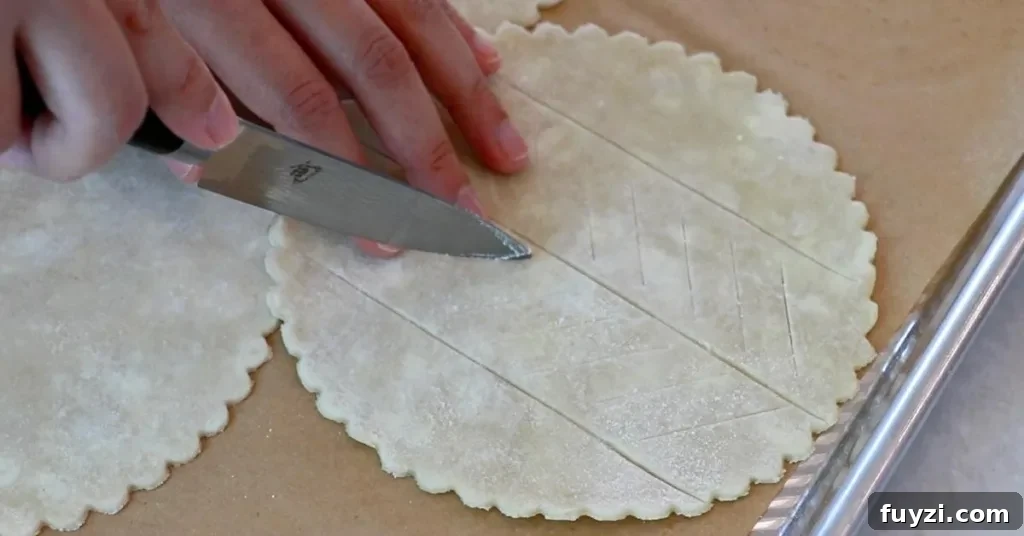 cutting the surface of pie dough for a blueberry pie
