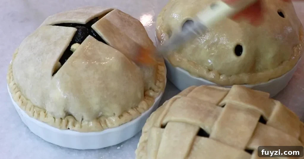 applying egg wash over a blueberry pie