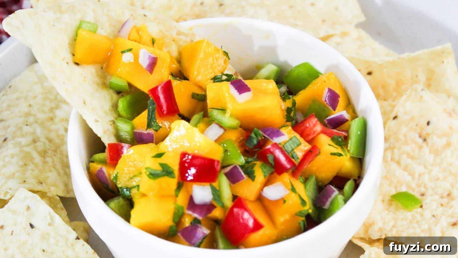 27 Crowd-Pleasing Outdoor Potluck Recipes for Late Summer 14 A white bowl filled with diced mango, red onion, red bell pepper, and green bell pepper salsa is surrounded by tortilla chips.