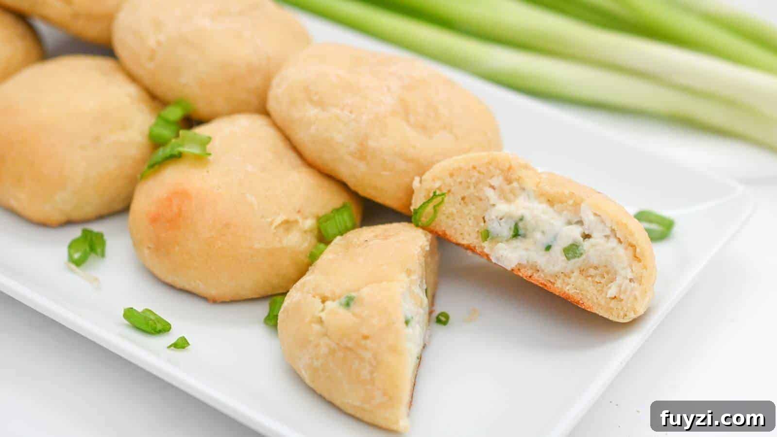 27 Crowd-Pleasing Outdoor Potluck Recipes for Late Summer 3 A plate of round, golden-brown buns with one cut open to show a filling mixed with green herbs. Green onions garnish the plate in the background.