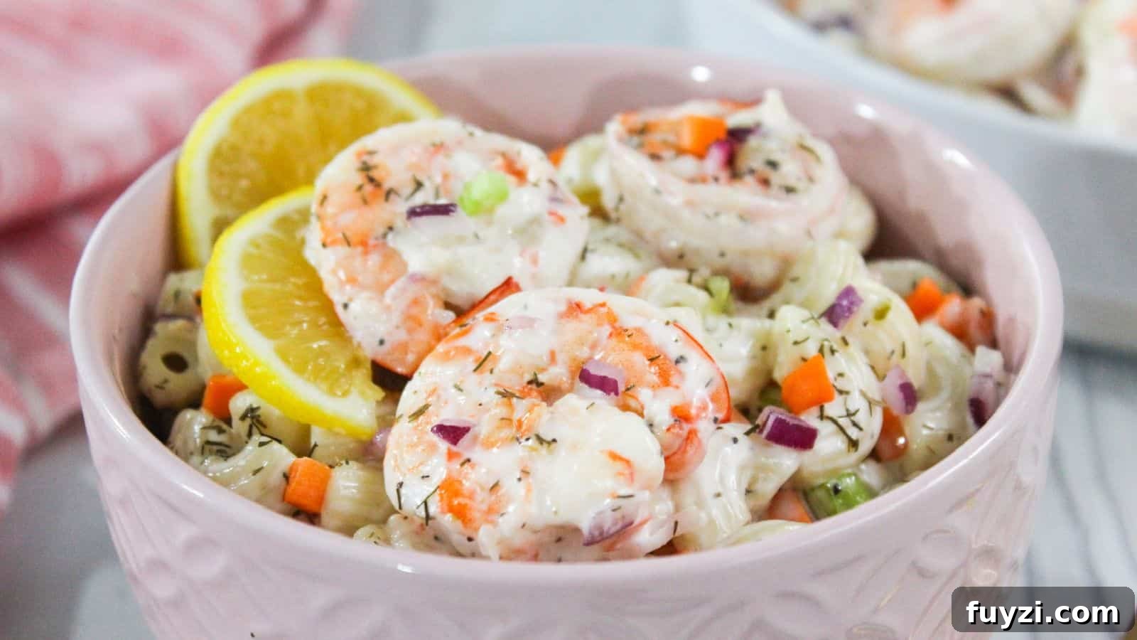 27 Crowd-Pleasing Outdoor Potluck Recipes for Late Summer 21 Shrimp macaroni salad in a pink bowl with lemon wedges.