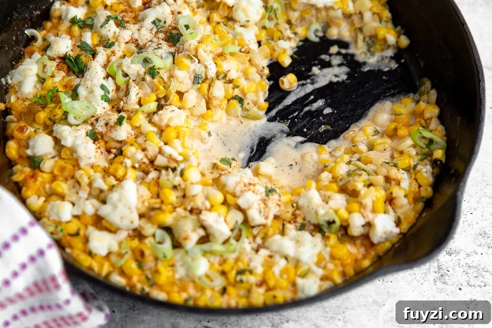 Half eaten elote dip in cast iron skillet