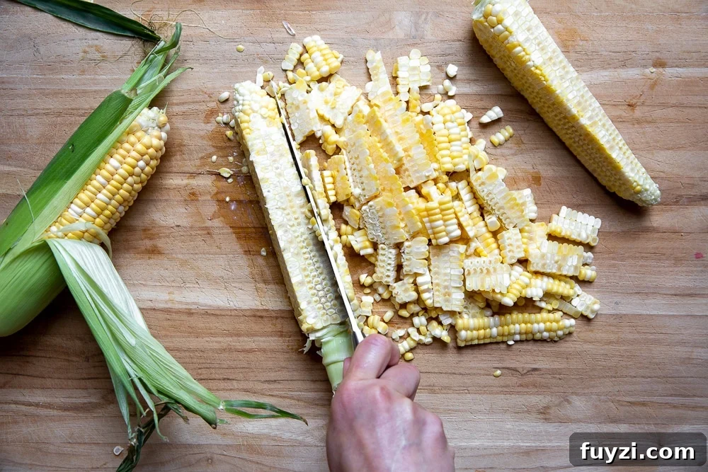Process shot showing how to cut corn kernels off the cob.