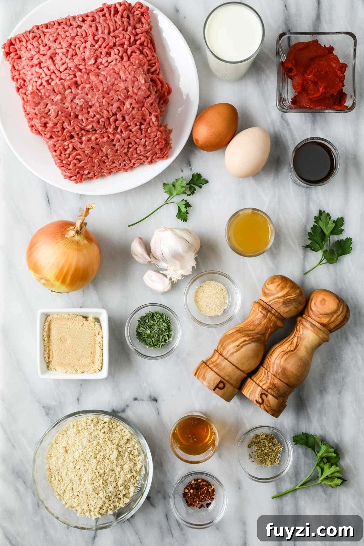 Overhead view of ingredients including ground beef, tomato paste, Worcestershire sauce, and more.