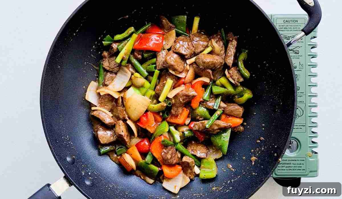 Restaurant-Style Black Pepper Beef Stir-Fry 8 Close up of stir fried beef and vegetables in a wok