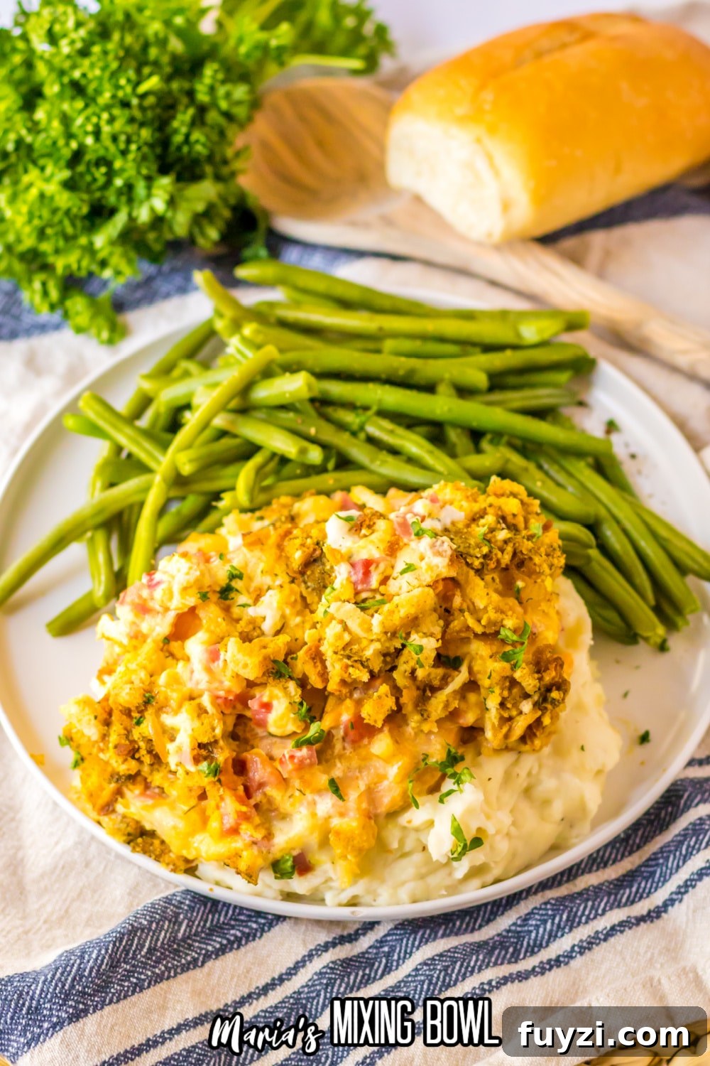 Slow Cooker Chicken Cordon Bleu Recipe with Ham and Swiss 9 plate with chicken cordon bleu casserole on top of a bed of mashed potatoes with a side of fresh green beans