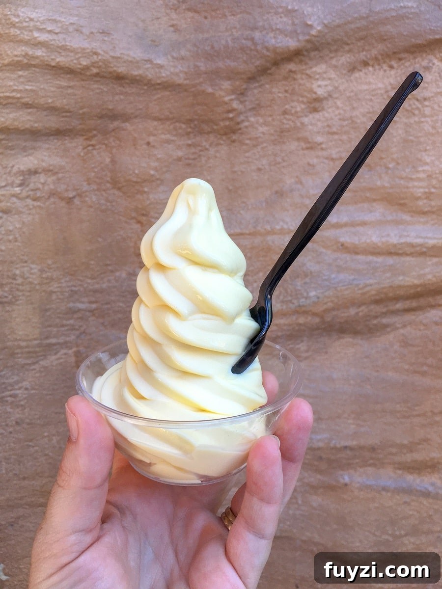 a hand holding a cup of Dole Whip soft serve at Disneyland, a naturally gluten-free treat
