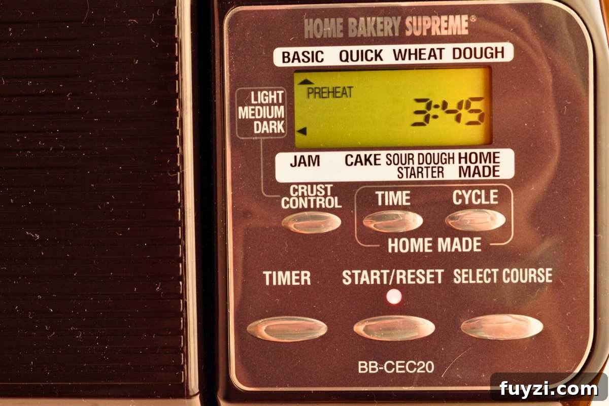 close up overhead shot of bread machine settings and buttons with basic selected and three hours and forty-five minutes as the timer.