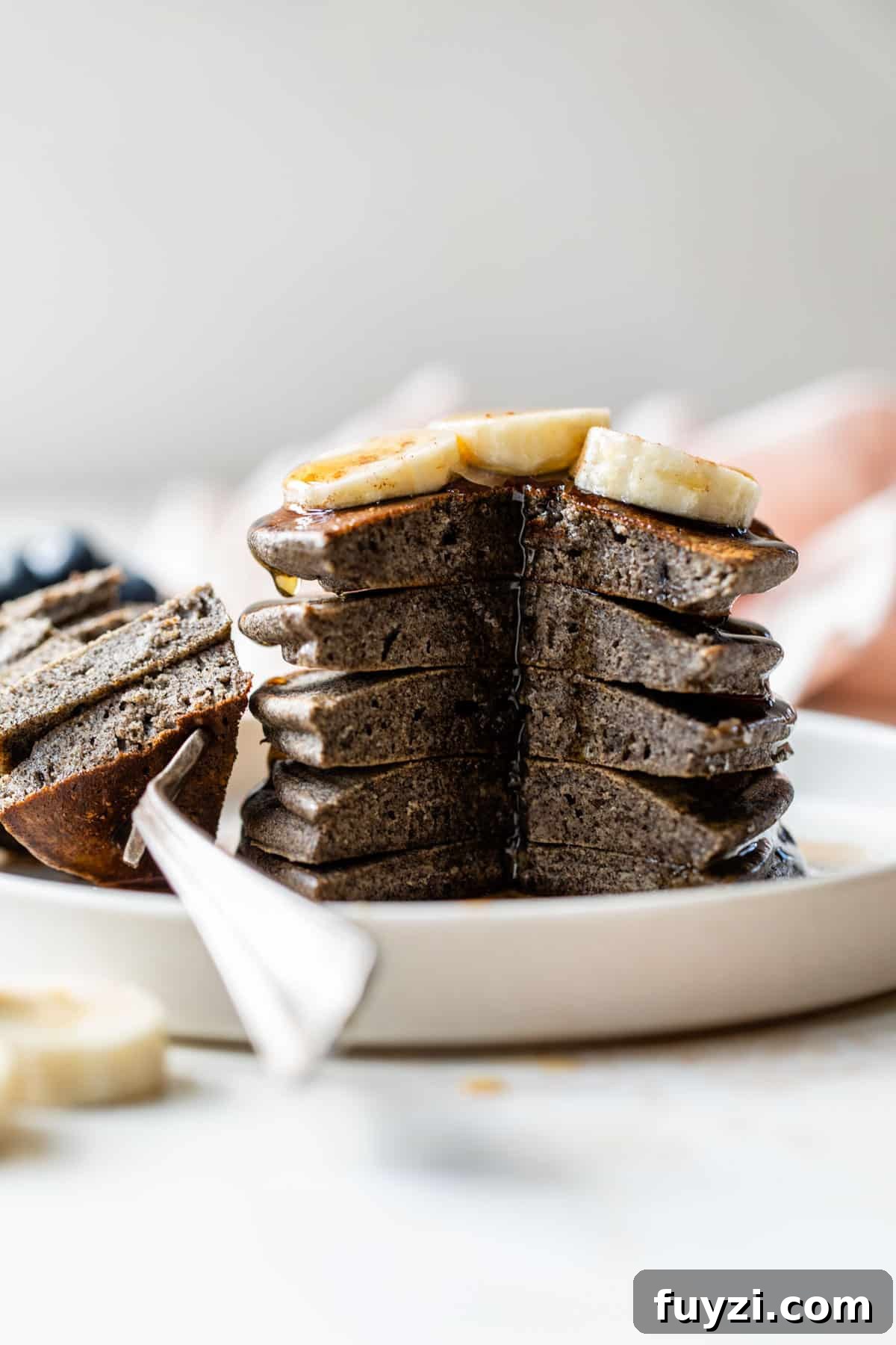 Fluffy Buckwheat Pancakes Recipe with Maple Syrup 6 a side view of a stack of pancakes with a large bite section taken out of the side