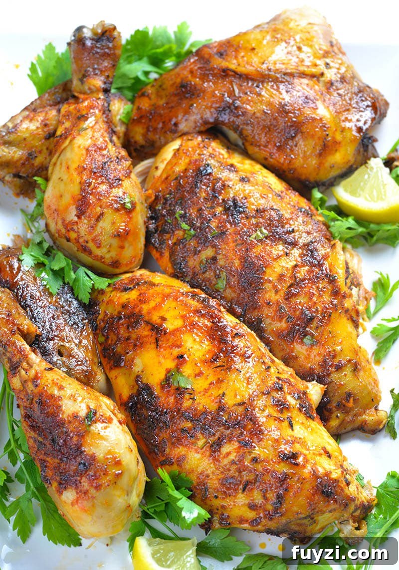Part of whole chicken cooked in a slow cooker laying on big white plate and garnished with parsley.