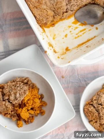 a piece of pumpkin dump cake in a bowl next to the pan