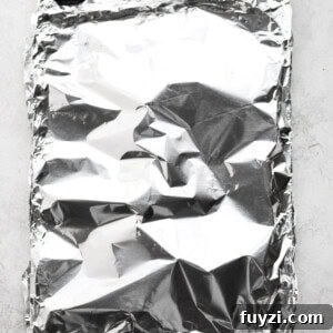 Oven-Baked Salmon in Foil: Flaky, Tender Fillets 5 sheet pan wrapped in foil.