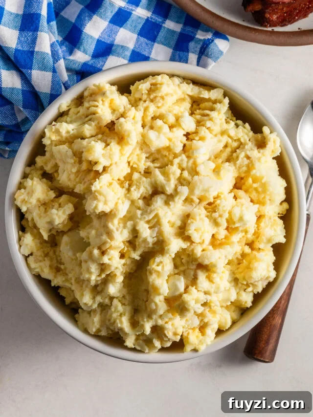 Bowl of Potato Salad with a blue and white plaid napkin in the background.