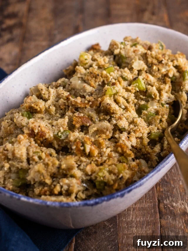 Serving dish of Cornbread dressing on a wooden background.