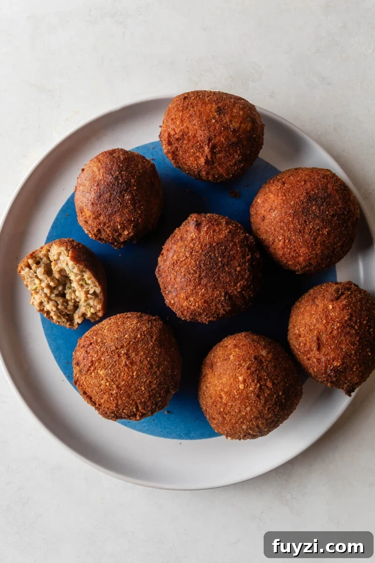 Circular white and blue plate with Fried Boudin balls.